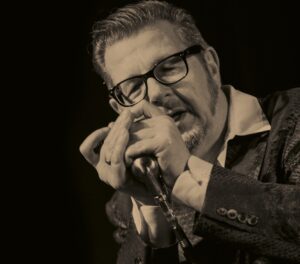 Dozent Dieter Kropp in schwarz weiß, er singt in ein Mikrofon