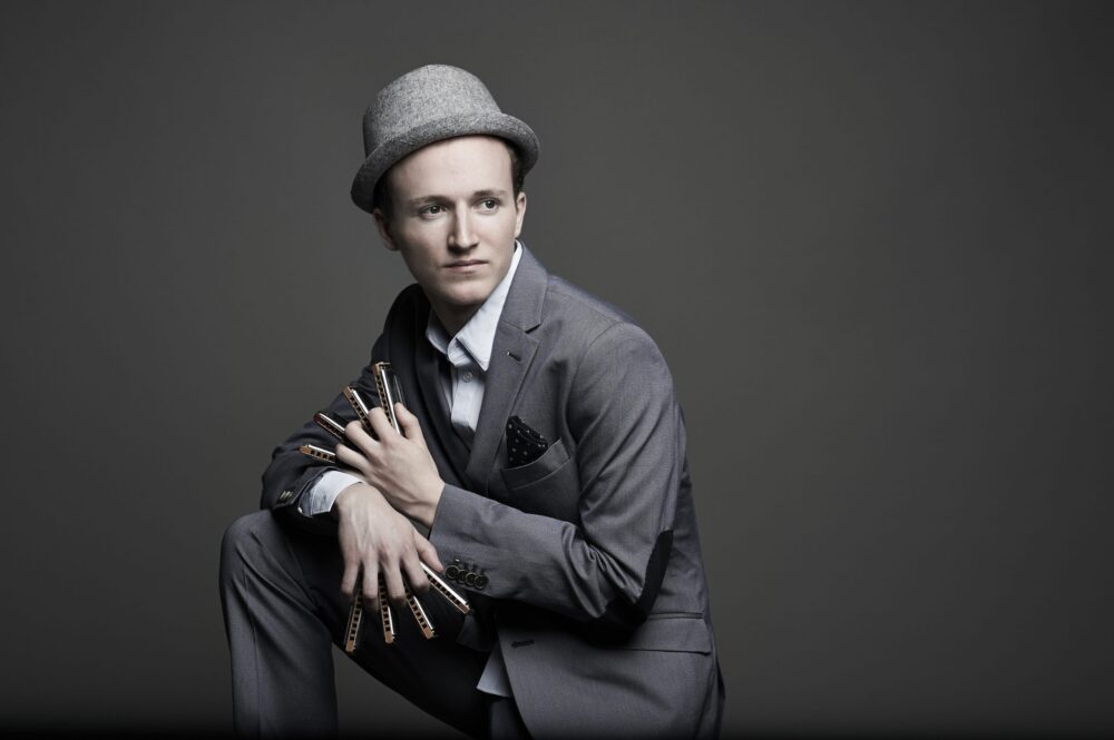 Musiker Konstantin Reinfeld trägt einen grauen Anzug und einen hellgrauen Hut