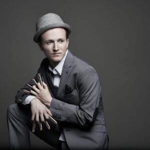 Musiker Konstantin Reinfeld trägt einen grauen Anzug und einen hellgrauen Hut