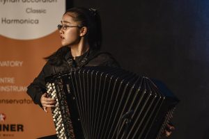 Musikerin auf der Akkordeon Grenzenlos Bühne die ein Akkordeon spielt