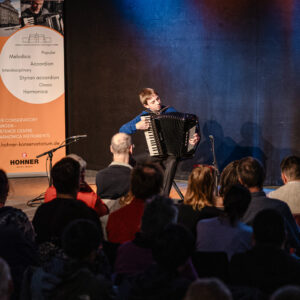 Ein musizierender Jugendlicher auf der Bühne beim Finalkonzert vor Publikum