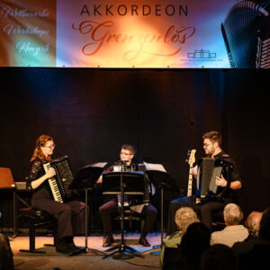Drei Musizierende auf der Bühne des Konzertabends Bei Akkordeon Grenzenlos