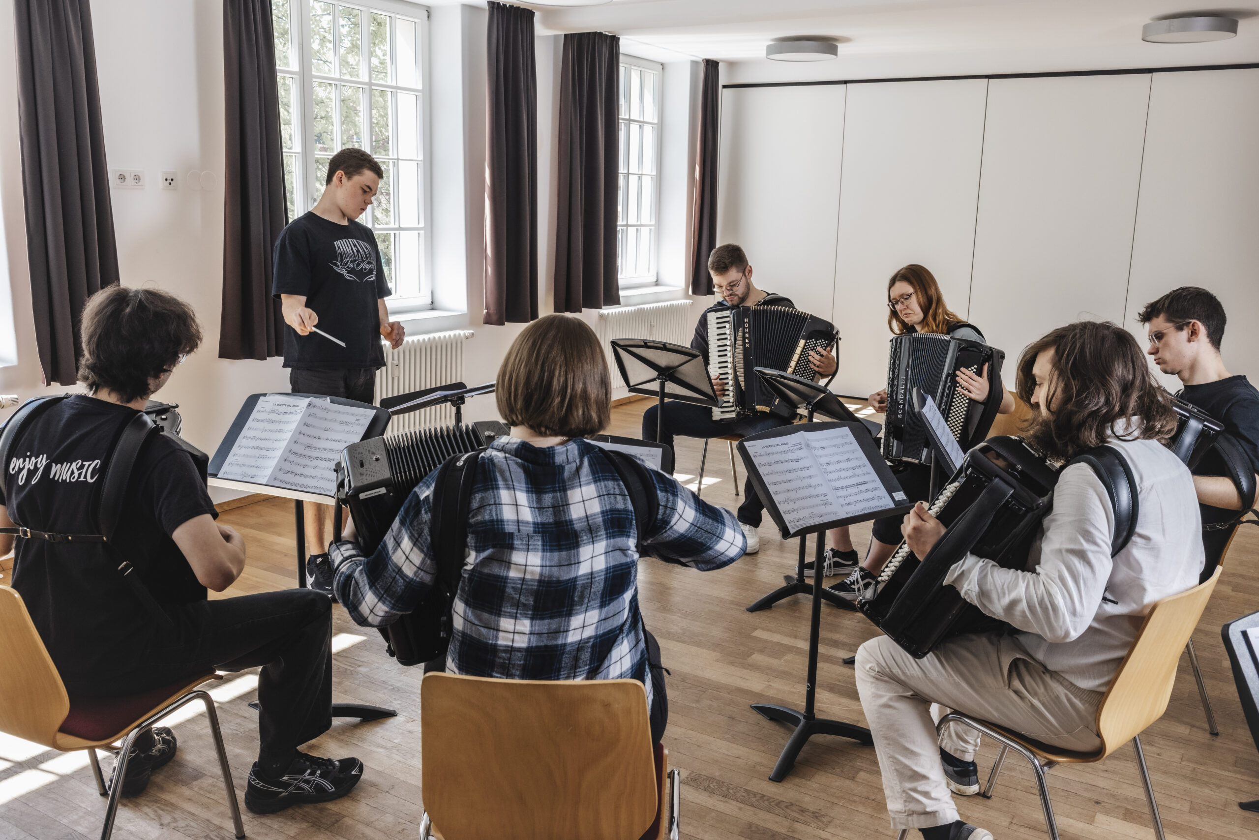 Dozent unterrichtet seine Musikschülerinnen im Klassenzimmer des Hohnerkons